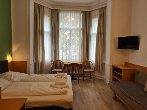 维也纳Pension Ani-Falstaff的酒店客房带两张床和一张桌子以及椅子。