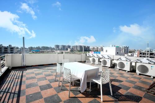 钱德加尔Hotel Woodcrest Zirakpur Chandigarh- Best Family Hotel的建筑物屋顶上的桌椅