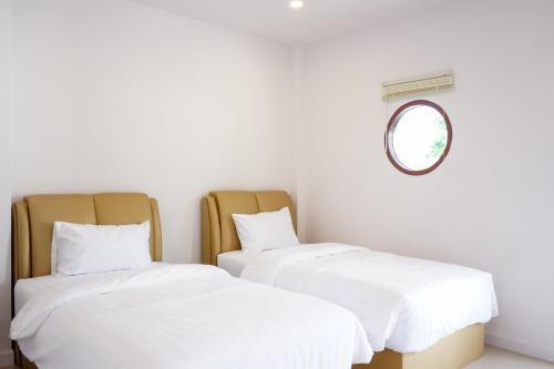 佛丕Chanmuang Resort ชานเมืองรีสอร์ท的配有镜子的客房内的两张床