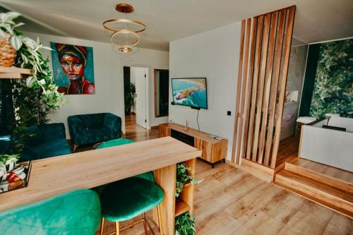 巴亚马雷Jacuzzi Apartment的客厅配有桌子和绿色椅子