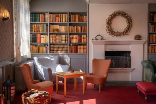 阿斯克尔Øvre Sem Gård的客厅配有椅子和带书籍的壁炉