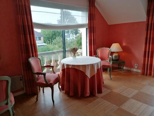 TéteghemLes Résidences du Moulin的客房设有桌椅和窗户。