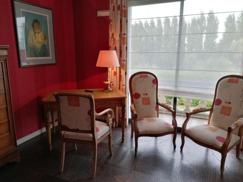 TéteghemLes Résidences du Moulin的客房设有两把椅子、一张桌子和一个窗户。
