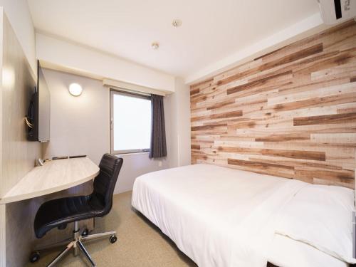 千叶千叶站前超级酒店的卧室配有白色的床和木墙