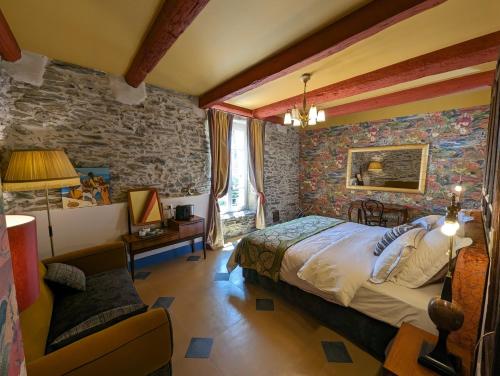 FaugèresLA GALANTE的一间卧室设有一张床和石墙