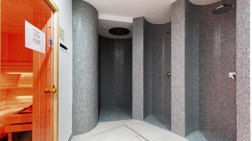 斯克拉斯卡波伦巴Apartament Przytulny Stone Hill的带淋浴的浴室和灰色的瓷砖墙壁