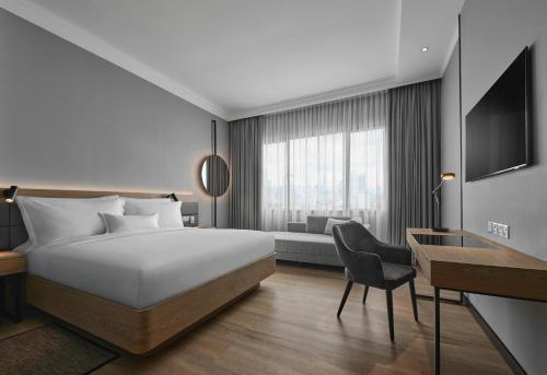 吉隆坡AC Hotel by Marriott Kuala Lumpur的配有一张床和一张书桌的酒店客房