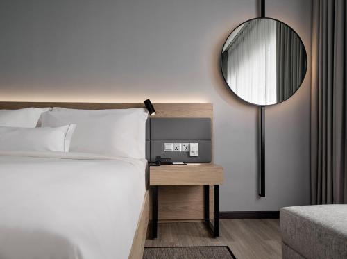 吉隆坡AC Hotel by Marriott Kuala Lumpur的卧室配有一张床,墙上设有镜子