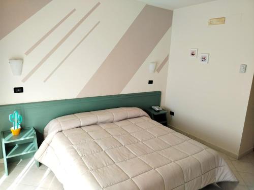圣乔瓦尼·罗通多Hotel Apulia的一间卧室配有一张带绿色床头板的床