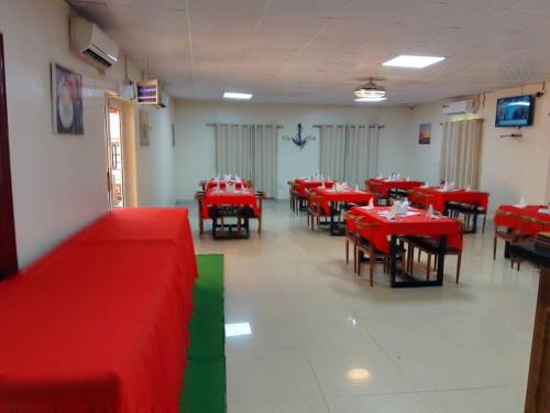 朱巴Lamerinn Hotel Juba的一间设有红色桌椅的用餐室