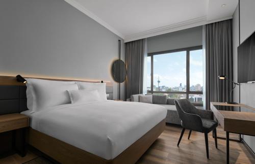 关丹AC Hotel by Marriott Kuantan的配有一张床和一张书桌的酒店客房