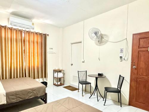 班敦孟PD Hostel的卧室配有一张床和一张桌子及椅子