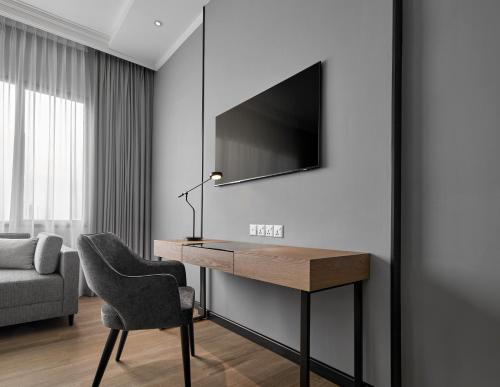 峇六拜AC Hotel by Marriott Penang的客房设有一张桌子、一把椅子和一台电视。