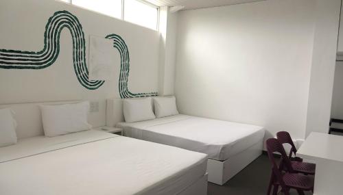 尼甘布City Beds Negombo的白色客房 - 带两张床和椅子
