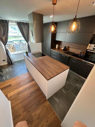 弗尔赫尼卡Apartment Bacci的厨房配有黑色橱柜和木制台面