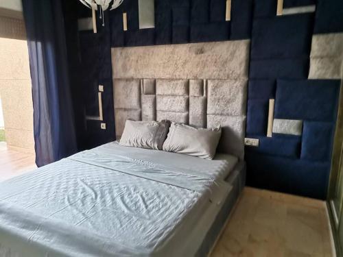 萨伊迪耶très belle maison avec jardin et piscine的一间卧室配有一张蓝色床头板的床