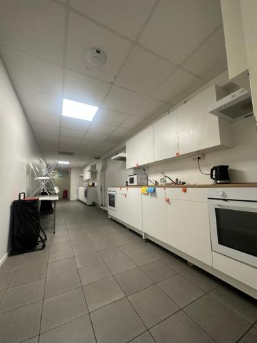 斯德哥尔摩波罗玛旅舍的一间大厨房,配有白色橱柜和电器