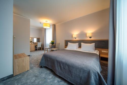 科沙林格罗马达酒店的酒店客房设有一张大床和一张书桌。