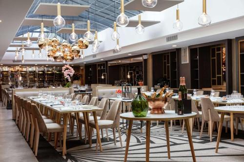 巴黎尼皮斯巴黎希尔顿Curio Collection酒店的用餐室配有桌椅和吊灯。