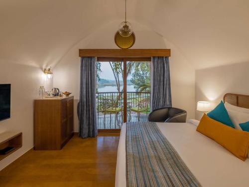 果阿旧城Mercure Goa Devaaya Resort的酒店客房设有一张床和一个阳台。