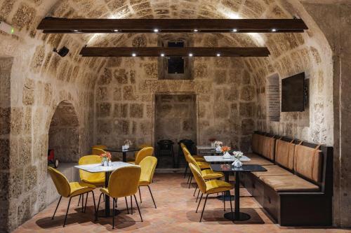 阿雷基帕Hampton by Hilton Arequipa的石头房里带桌椅的餐厅