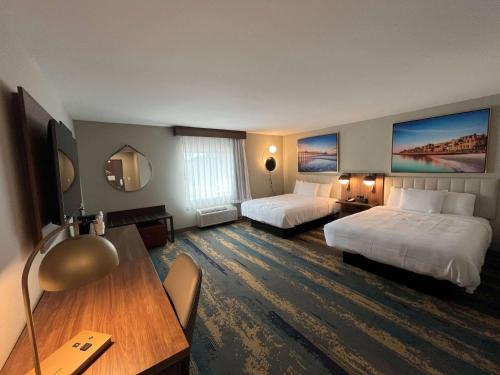 哥伦比亚La Quinta Inn by Wyndham Columbia NE Fort Jackson的酒店客房配有两张床和一张书桌