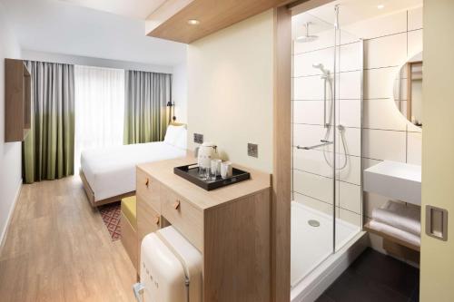 罗奇代尔Hampton By Hilton Rochdale的酒店客房设有带一张床和淋浴的浴室