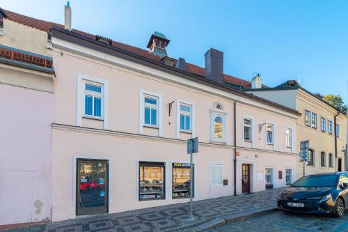 布拉格Bookhouse apartment by Prague Castle的前面有一辆汽车停放的白色建筑