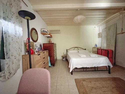 MantoúkionFiloxenos Houses Corfu Island的一间卧室配有一张床、镜子和椅子