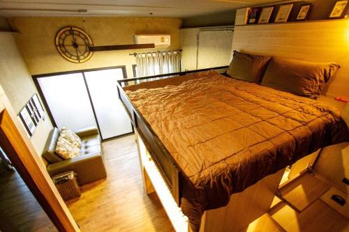 曼谷44 Room Rama 3的一间卧室配有一张大床和一把椅子