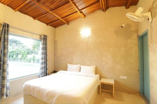 BhundsiBrahmaputra cafe and resort的卧室配有白色的床和窗户。