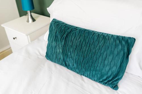 莫克姆Spacious & Stylish 5 Bed with Free Street Parking的白色床顶上的绿色枕头