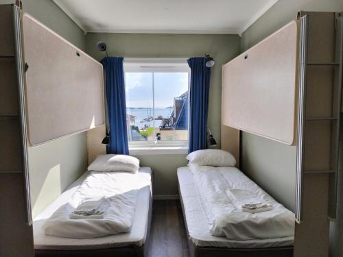 克里斯蒂安桑Sjøgløtt Gjestgiveri的小型客房 - 带2张床和窗户