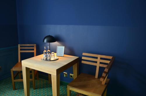 布科Bellevue Gastgeberei的蓝色墙壁的房间里一张桌子和椅子