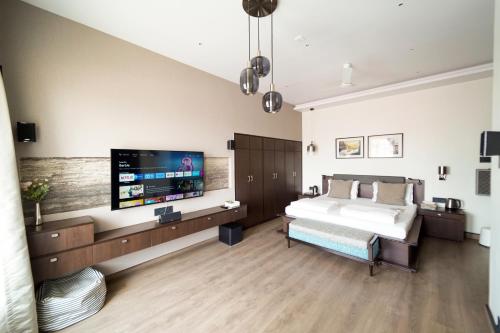 加尔各答城中心住宿加早餐旅馆的一间卧室配有一张床和一台平面电视