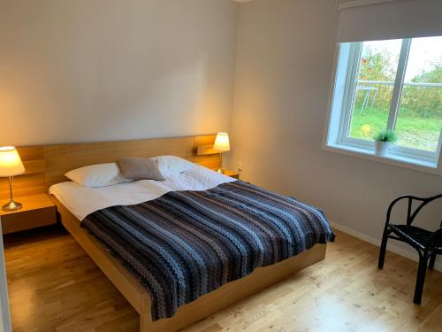 菲奈斯达伦Funäsdalsporten Röda Husen Funäsdalen的一间卧室配有一张带条纹毯子的床和窗户