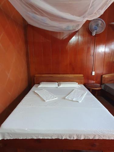 永隆巴林民宿的小型客房的一张床位,设有木墙