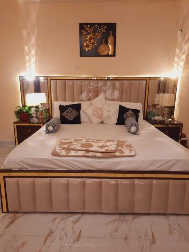 卡拉奇Charming Home banglow的卧室配有一张带白色床单和枕头的大床。