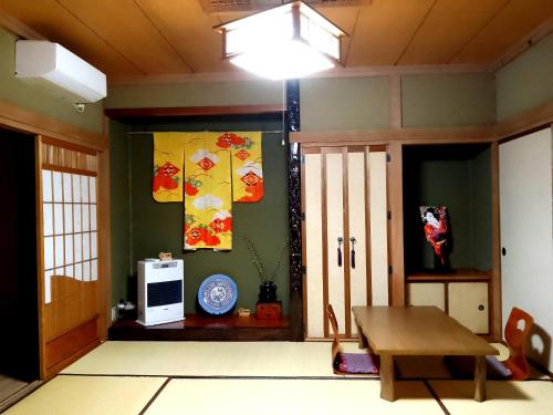 小樽Plum House Otaru的一间设有桌子的房间和一扇带电视的门