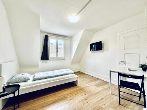 巴尔斯塔尔Monteurzimmer ZIMMERzuVERMIETEN in Balsthal Solothurn的白色的客房配有一张床和一张书桌