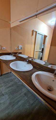 Dajti Paradise Hostel的一间带四个盥洗盆和大镜子的浴室