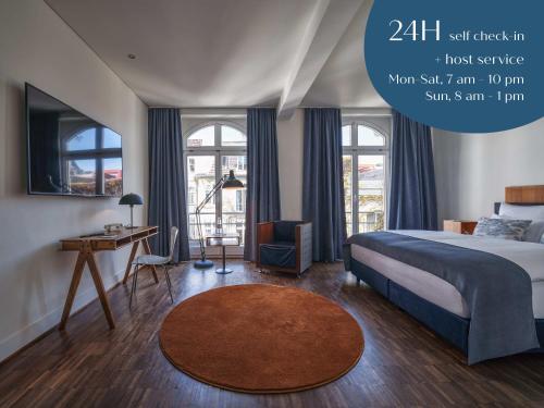 科隆Classik Hotel Antonius的卧室配有一张床、一张书桌和窗户。