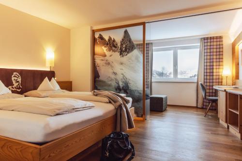 上陶恩Hotel Römerhof Superior的酒店客房设有一张床和一个大窗户