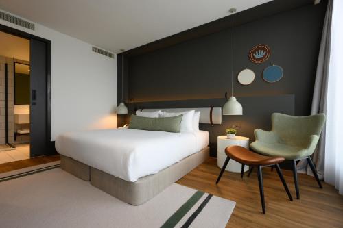 奥斯特韦克NEO KVL Hotel by TASIGO的一间卧室配有一张床、一把椅子和一张桌子