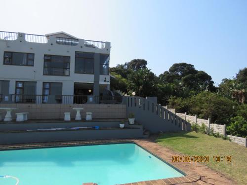 马盖特Beachcomber Bay Guest House In South Africa的房屋前有游泳池的房子