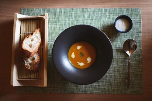 神户結びの小宿 縁的桌上的一盘面包和一碗汤