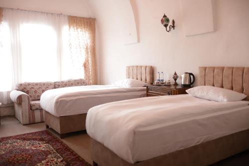 内夫谢希尔Cappadocia Landscape House的一间卧室设有两张床和窗户。