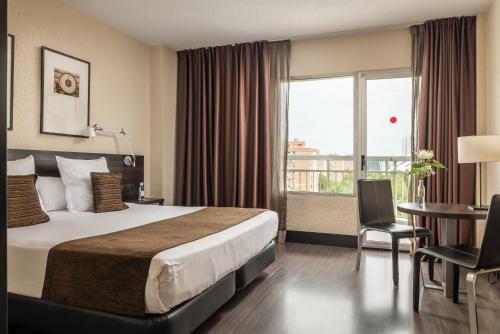 瓦伦西亚瓦伦西亚媒介酒店的配有一张床、一张书桌和一扇窗户的酒店客房