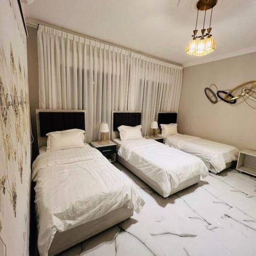 亚喀巴Luxury 4-bedrooms apartment的配有两张床铺的酒店客房,铺有大理石地板