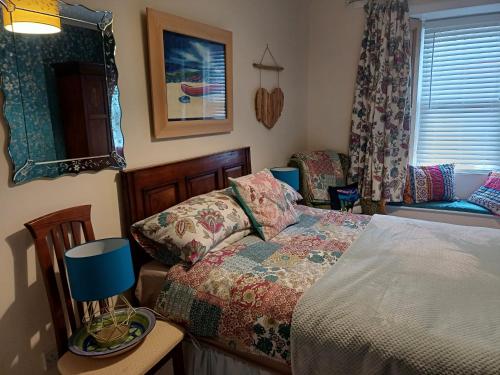 皮布尔斯The Hideaway的一间卧室配有一张床、一张桌子和一个窗户。